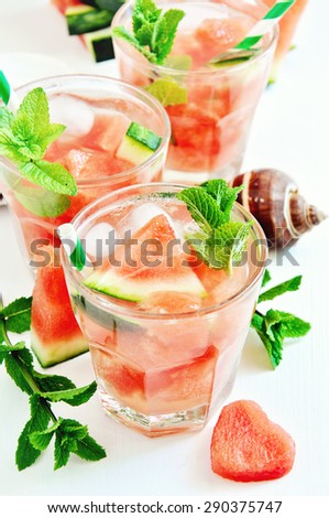 Refreshing watermelon drink with mint and ice cubes for summer hot day, sea shells, selective focus, toned image.