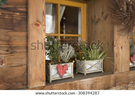 rural house with flowers on a wooden window sill