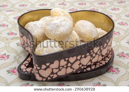 ?ookies in powdered sugar in a tin box in heart shape