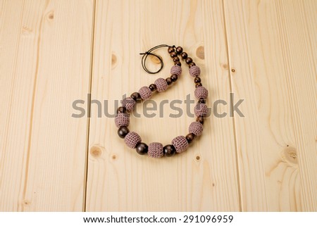 Brown crochet handmade beads on a light wooden table