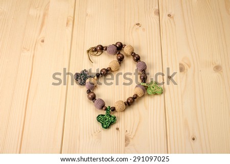 Crochet baby handmade beads with acorns and leaves on a wooden table