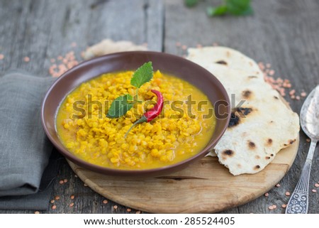 Thick indian red lentil soup with chili served with indian flat bread