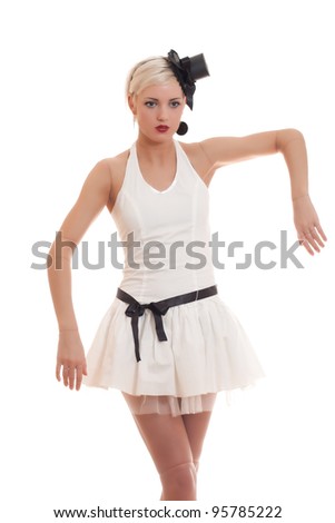 Beautiful young woman in white dress with small hat and black belt is acting as a living doll, isolated on white