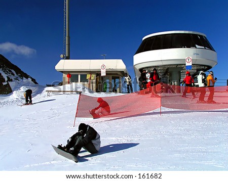 Snow boarder with ski-lift station and blue sky
