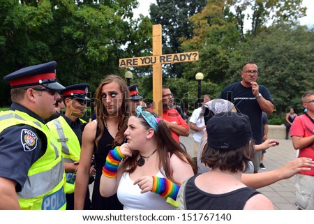 OTTAWA - AUG 25:  Gay Pride participants talk to police as a Christian preaches against homosexuality after the crowd decides to stop listenting at the annual Gay Pride Parade Aug 25, 2013 in Ottawa