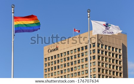 OTTAWA - FEB 8: The Gay Pride flag is flown at Ottawa City Hall, with the Dept of National Defense HQ in the background, to show support for Gay Rights in Sochi Feb 8, 2014 in Ottawa, Canada