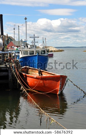 Fishing boats tied to wharf in scenic fishing village of Peggy\'s Cove, Nova Scotia