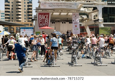 TORONTO, CANADA – JUNE 5: People ride stationary bikes to raise money for HIV/AIDS related programs in Africa in the annual Dignitas Race For Dignity in Yonge-Dundas Square on June 5, 2011 in Toronto, Ontario, Canada.