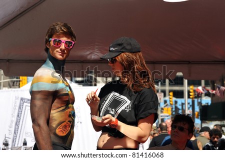 TORONTO, CANADA – JUN 19: An unidentified male model gets touched up by body painter during the Celebrate Bloor festival to celebrate the renovation of Bloor Street June 19, 2011 in Toronto, Ontario.