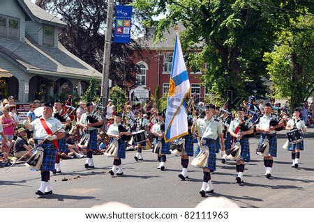 DARTMOUTH, CANADA - AUG 1:  A marching band, carrying a Nova Scotia flag and wearing the Nova Scotia tartan, marches in the 116th Natal Day Parade Aug 1, 2011 in Dartmouth, Nova Scotia.