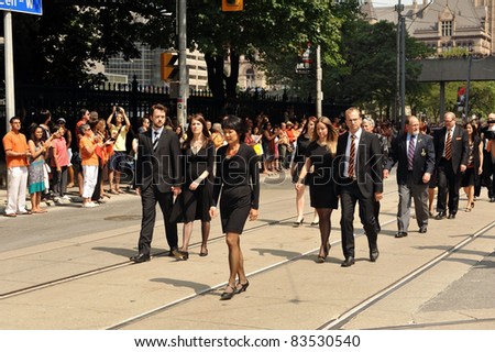 TORONTO, CANADA - AUG 27:  Olivia Chow, the widow of Jack Layton, and Jack’s children Sarah and Michael walk in the funeral procession to the state funeral Aug 27, 2011 in Toronto, Ontario.