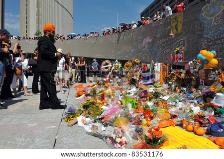 TORONTO, CANADA - AUG 27:  People gather and  leave messages and items at City Hall to pay respect to Jack Layton.  His body lay in state there before his funeral Aug 27, 2011 in Toronto, Ontario.