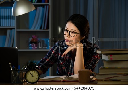 young bored female college student studying poorly at late evening before exam, funny night procrastination concept. mixed race asian chinese model.