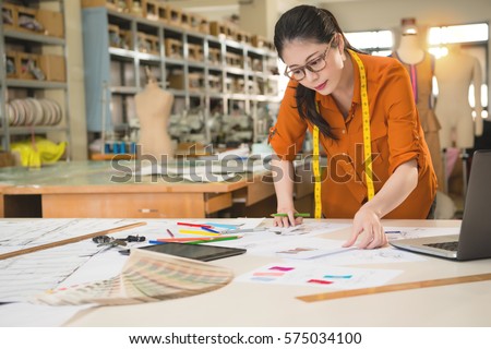 beautiful fashion woman designer choice looking for best match market design sketch with fabric sample in manufacturing office studio. profession and job occupation concept.