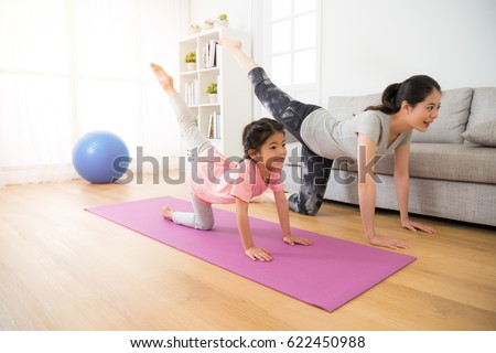 asian pretty mother and her youth kid daughter in the gym center doing stretching fitness exercise yoga together, parent accompany children sport concept.