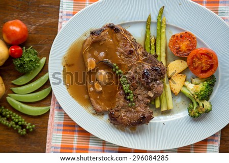 Grilled T-bone steak Sauce seasoned with gravy served with vegetables.