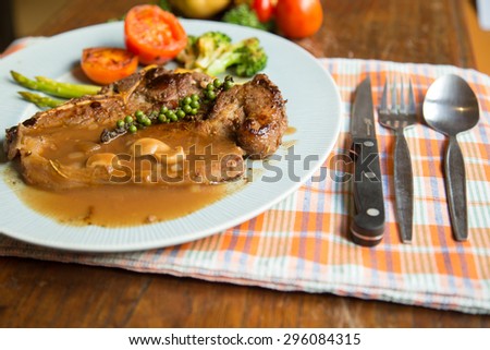 Grilled T-bone steak Sauce seasoned with gravy served with vegetables.