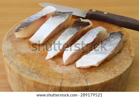 Fresh raw fish fillet of sea bass on chopping block isolated