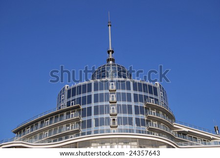 Steeple and penthouse of modern round building of glass.