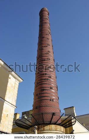 Ancient industrial brick chimney forced with steel bands.