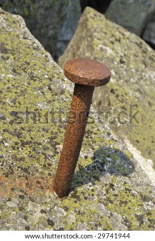 stock-photo-big-rusty-nail-half-hammered-in-natural-stone-29741944.jpg