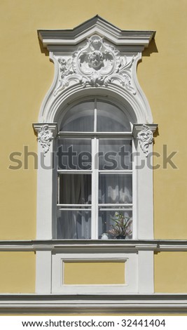 Ancient palace window decorated with floral relief and angel head.