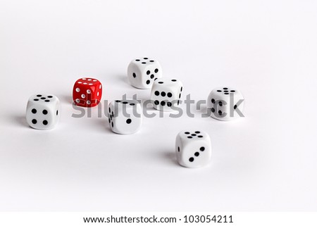 Randomly scattered white dice with one red dice conceptual of individuality