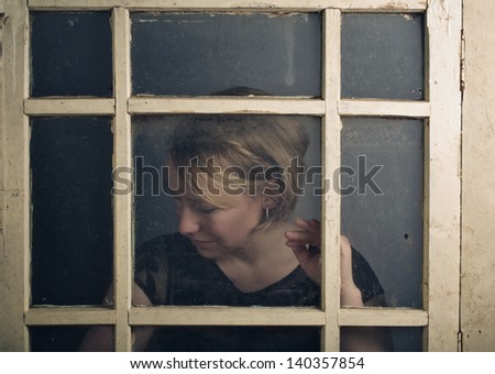 Portrait of a blone adult woman with old rustic Window