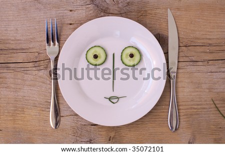 Vegetable Face on Plate with knife and fork, set on wooden board - Female, Happy