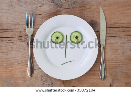 Vegetable Face on Plate with knife and fork, set on wooden board - Male, Shocked