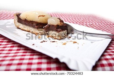Piece of fruit cake with part already eaten on plaid cloth