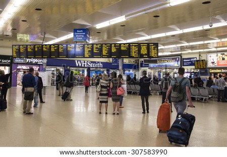 LEEDS, UK - 23 JULY 2015.  Passengers looking at the train departure and arrival information boards inside the main area of Leeds train station.
