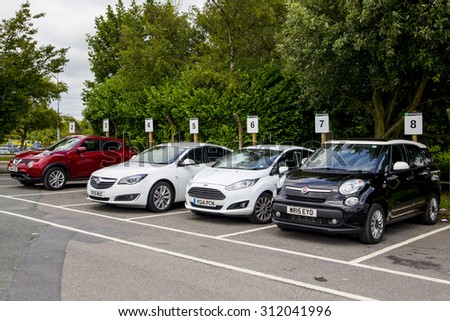 LEEDS, UK - 20 AUGUST 2015. A line of hire cars parked at the Enterprise car rental desk in Leeds Bradford Airport