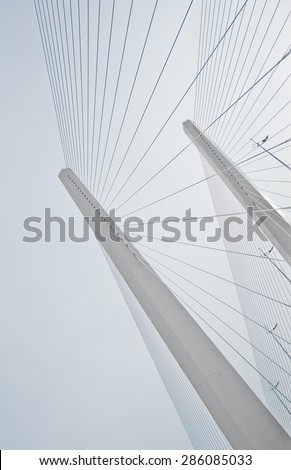 Two pylons of a bridge with supporting cables going down in a line pattern