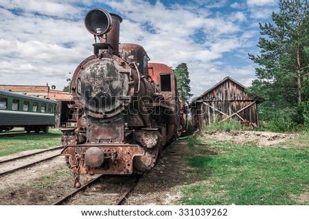 Old rusty steam train locomotive sitting on old rail track in the middle of nowhere
