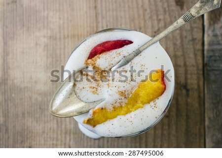 baked peach and vanilla ice cream in a glass on wooden background