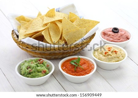 Tortilla Chips With Four Super Bowl Dips Which Are Salsa Roja, Guacamole, Taramasalata, And Hummus.