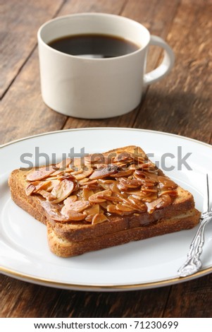 a cup of coffee and toast with almond slices