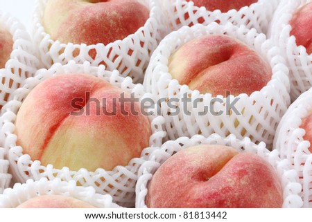 fresh white peaches in fruit net