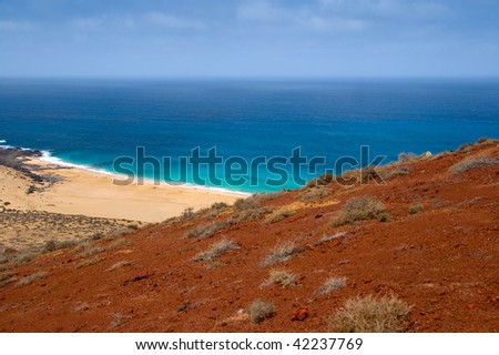 Sand beach under a red volcano in Lanzarote