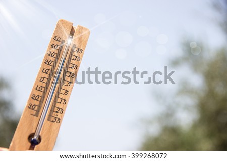 thermometer pointing to the sky to symbolize the heat of summer