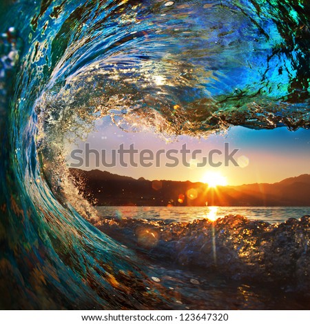 rough colored ocean wave falling down at sunset time