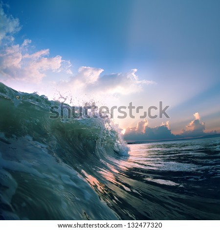 Summer design template. Beautiful sunset with surf and sunlight through breaking wave