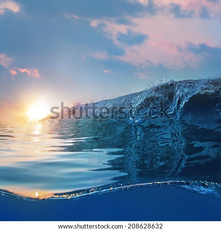 Beautiful blue ocean surfing wave under sunset