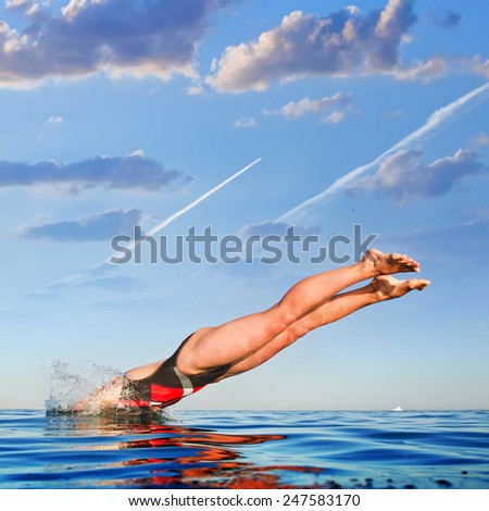 Female professional swimmer jumping into water
