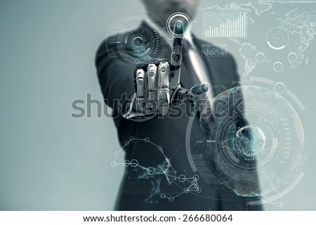 Businessman With Artificial Robotic Hand working on virtual holographic interface. Future technology as design concept.