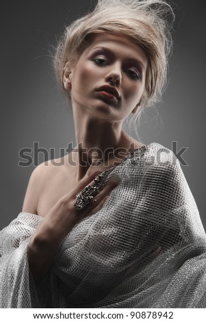 fashion beautiful glamour girl with creative stylized hair wearing silver fishnet and steel accessories
