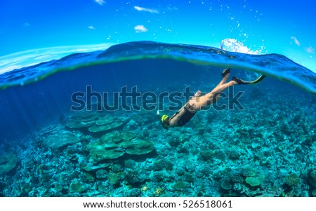 Underwater image of a young lady snorkeling and diving in a tropical sea