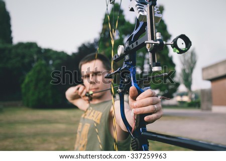 Young boy shooting a bow and arrows
