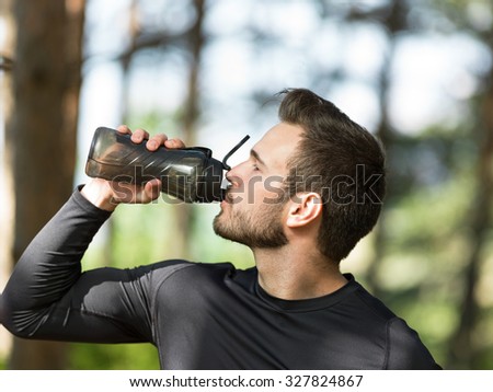handsome man drinking water on a sunny day